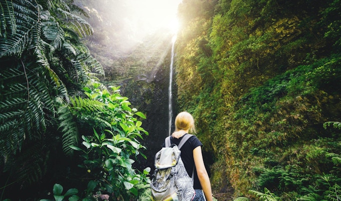 Ung kvinne som nyter fossen Caldeiré Verde mens hun vandretur på Madeira.