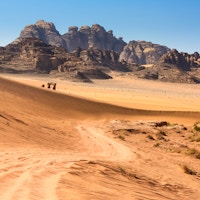 Arkivfoto av en ørkenvei som fører gjennom Wadi Rum-ørkenen også kjent som Månedalen, et UNESCOs verdensarvsted i Jordan.