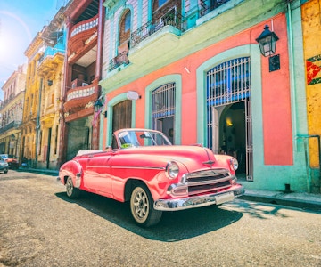 Vintage rosa oldtimer bil kjører gjennom gamle Havana Cuba