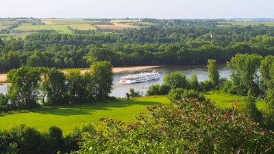 Skipet MS Loire Princesse på elven i den grønne, frodige Loiredalen med åkre i bakgrunnen