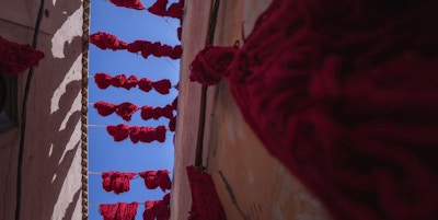 Farget rød ull til tørking over soukene i Marrakech.