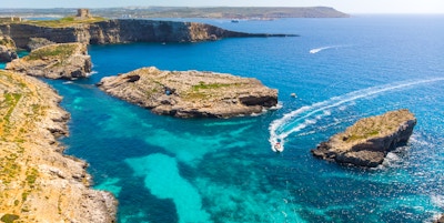 Luftfoto av Comino-øya og noen få båter over havet. Dronelandskap. Europa. Malta
