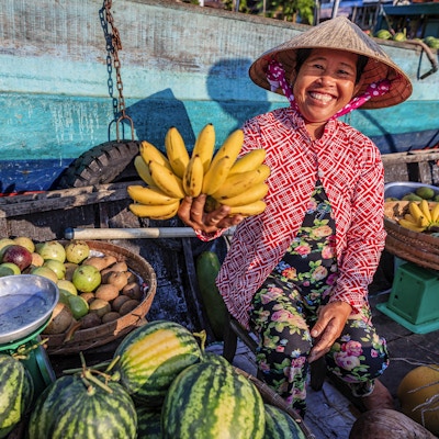 Vietnamesisk kvvinne som selger bananer på et flytende marked, Mekong-elven, Vietnam