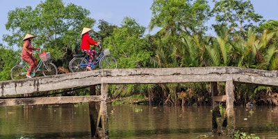 Vietnamesiske kvinner sykler, Mekong River Delta, Vietnam