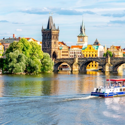 Byutsikt over elvebredden med broen og gamlebyen i Praha