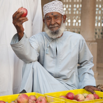 Senior omansk mann i tradisjonelle klær; dishdasha og kummah cap, ser på kameraet på markedet i Nizwa.
