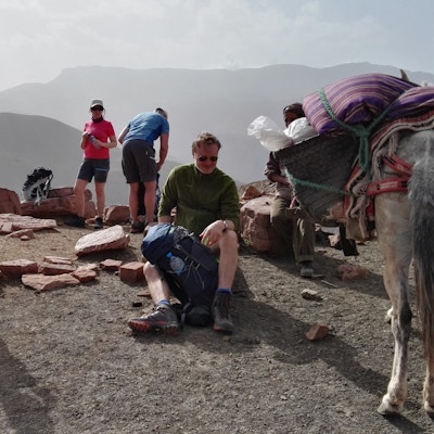 Mennesker og muldyr tar en pause i fjellene i Marokko.