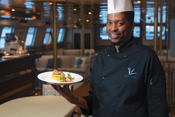 Mann serverer mat på cruiseskip.