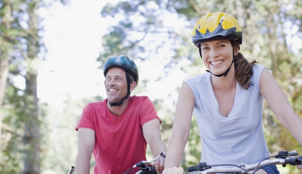Par på sykkeltur med hjelm.