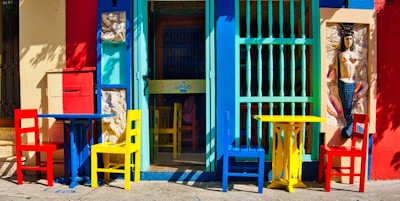 Fargerikt møbler utenfor en kafe i en solfylt bygate