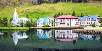 Islandsk landskap, utsikt over Seydisfjordur med hus og speiling i sjøfjordvann, Island