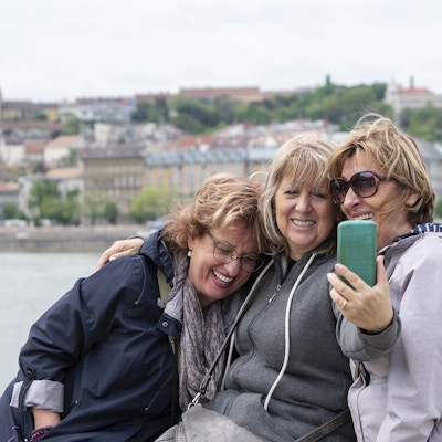 Kvinnelige seniorvenner utforsker byen på ferie.