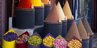 Tilbredelse av krydder og blomster i et lokalt medinamarked i Fez, Marokko
