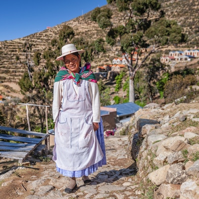 Aymara-kvinne som går på Isla del Sol (Island of the Sun), Titicacasjøen, Bolivia. Isla del Sol er en øy i den sørlige delen av Titicacasjøen. Det er en del av den moderne flernasjonale staten Bolivia. Geografisk er terrenget hardt; det er en steinete, kupert øy. Det er ingen motorkjøretøyer eller asfalterte veier på øya. Den viktigste økonomiske aktiviteten til de rundt 800 familiene på øya er jordbruk, med fiske og turisme som forsterker livsoppholdsøkonomien. Av flere landsbyer er Yumani og Cha'llapampa de største. Det er over 80 ruiner på øya. De fleste av disse dateres til inkaperioden rundt 1400-tallet e.Kr. Arkeologer har oppdaget bevis på at folk bodde på øya så langt tilbake som det tredje årtusen fvt. Mange åser på øya inneholder jordbruksterrasser, som tilpasser bratt og steinete terreng til jordbruk. Blant ruinene på øya er Sacred Rock, en labyrintlignende bygning kalt Chicana, Kasa Pata og Pilco Kaima. I religionen til inkaene trodde man at solguden ble født her.