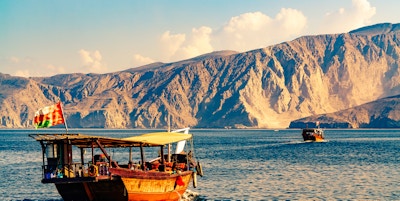 Båttur i Omanbukten med fjell i bakgrunnen.