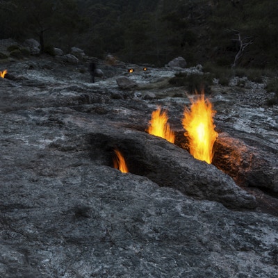 Brannene til Yanartas (flammende stein) om natten, Antalya, Tyrkia. små branner som stadig brenner fra ventiler i steinene på siden av fjellet. Området ligger på et spor som er populært blant turgåere og vandrere på Lycian Way.