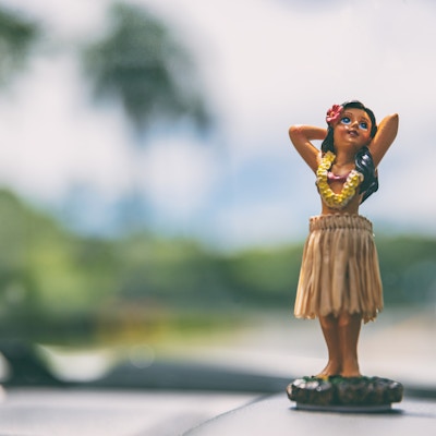 Hawaii roadtrip - bil hula danser dukke danser på dashbordet foran havet. Konsept for turisme og reisefrihet.